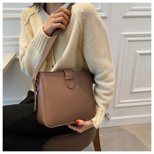 Verstellbarer dünner Schultergurt und goldene Details der vintage braunen Eimertasche