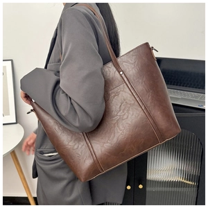 Grand sac cabas vintage en similicuir marron porté par un mannequin en studio