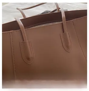 Detail showing high-quality stitching and smooth dark brown leather of the tote bag strap