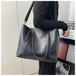 Vue lifestyle d'un grand sac cabas en cuir ciré noir avec bandoulière réglable
