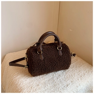 Detail view of brown plush faux fur Boston bag with leather handles and gold zippers