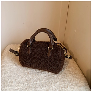 Detail of dark brown plush faux fur fabric and smooth leather handle on Boston bag