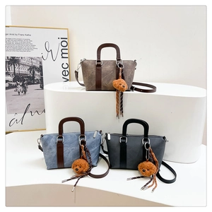 Detailed shot of three vintage trapezoid bags in dark coffee, denim blue, and black colors