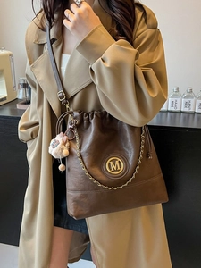 Deep brown leather bucket bag with gold M logo, chain detail and sheep charm