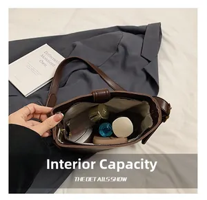 Vue de dessus de l'intérieur spacieux d'un sac seau marron foncé avec des objets du quotidien