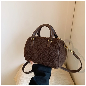 Detailed close-up of dark brown plush Boston bag with premium faux fur and leather handles