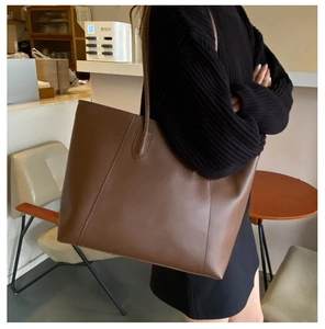 Side view of a vintage dark brown tote bag in matte faux leather with long slim straps