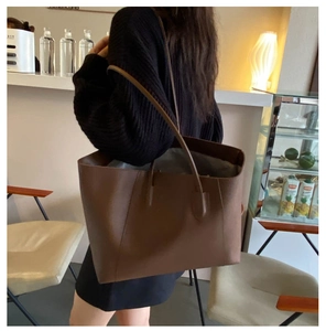 Detail of dark brown leather tote bag showing spacious interior for daily commute use
