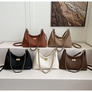 Detail showing five colors of pleated leather shoulder bags with gold chain straps