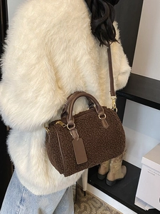 Deep brown plush Boston bag with PU handles shown on model in an autumn street setting