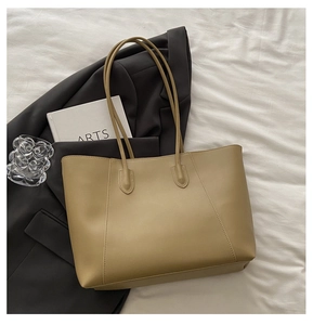 Detail of khaki tote bag with V-shaped stitching on textured fabric background