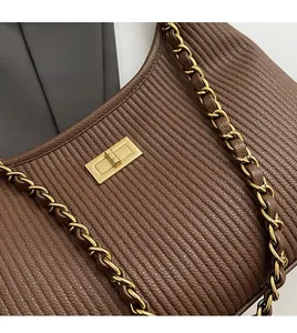 Close-up of vintage dark brown striped leather tote with gold twist lock and chain strap