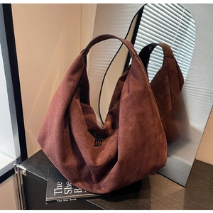 Close-up of brown suede hobo bag with smooth dual zippers and minimalist texture