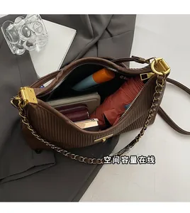 Close-up of the large interior capacity and pleated texture of the brown chain bag