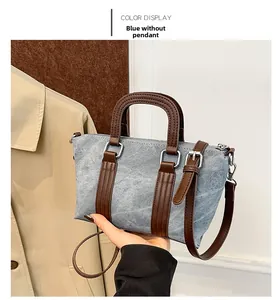 Blue denim pillow bag featuring brown leather handles and adjustable shoulder strap