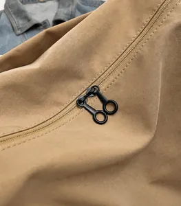Detalle de la cremallera doble de metal y la resistente lona caqui del bolso bandolera