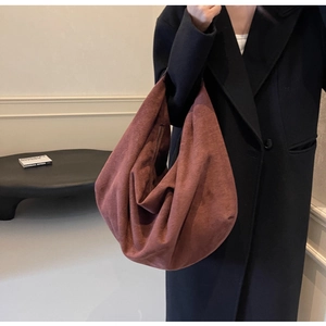 Detail of suede hobo bag in caramel color showing soft texture and zipper closure