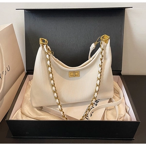 Detail of off-white corduroy chain bag with gold buckle in an elegant black gift box
