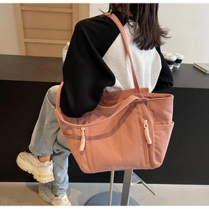 Details einer rosa Cord-Einkaufstasche mit Rippstruktur und Seitentasche im Café