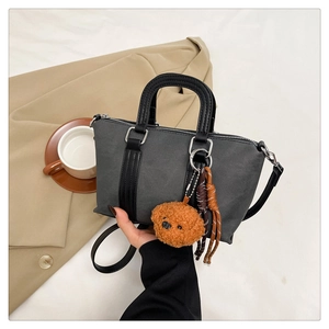 Detailed view of vintage grey pillow bag featuring leather straps and teddy charm