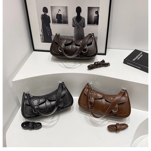 Detailed close-up of fashion shoulder bags in black and brown leather with front pockets