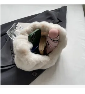 Spacious interior of white faux fur plush tote bag holding a phone, wallet, and umbrella