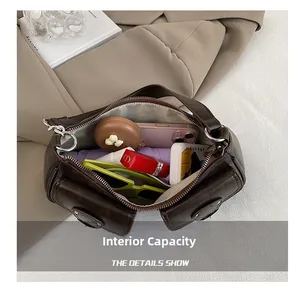 Interior view of small brown shoulder bag showing large capacity for daily essentials