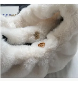Detail shot of a plush white faux fur handbag with a premium gold magnetic clasp and chain