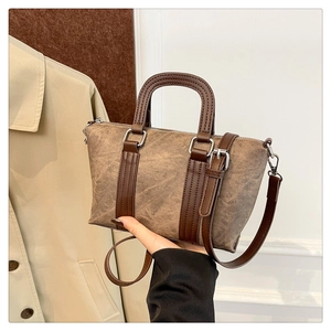 Detail shot of vintage satchel bag with textured fabric and dark brown leather accents
