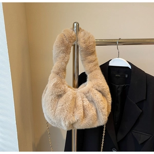 Detailed texture of the beige faux fur handbag with golden chain strap and pleated bottom