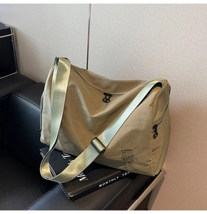 Detalle del bolso tote caqui con bordado MUL MIDI ON y correa de tela ajustable