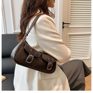 Detail of dark brown vintage faux leather shoulder bag with dual buckle flap pockets