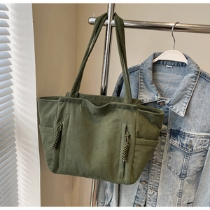 Detailansicht der militärgrünen Cord-Einkaufstasche mit Seilreißverschlüssen und Taschen