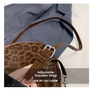 Detail des verstellbaren braunen Leder-Schultergurts mit Silberschnalle an der Leoparden-Tasche