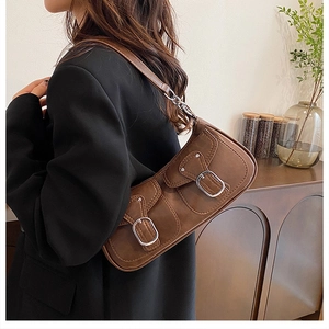 Brown vintage PU leather shoulder bag with double flap pockets on a model indoors