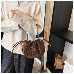 Lifestyle-Foto einer Beuteltasche mit Leopardenmuster, Kordelzug und schmalem Gurt