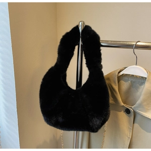 Detail of black faux fur hobo bag with plush texture and golden metal chain link
