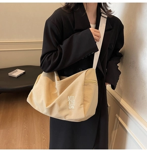 Modelo con bolso tote de lona caqui grande con correa ancha y letras minimalistas