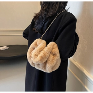 Detail view of apricot faux fur crossbody bag with elegant gold chain strap texture