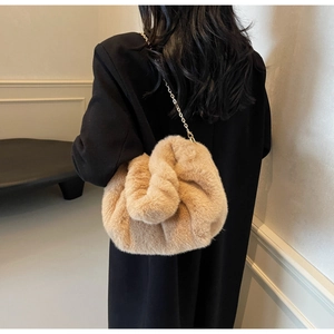 Detail of soft khaki faux fur texture and golden metal chain strap on a plush handbag