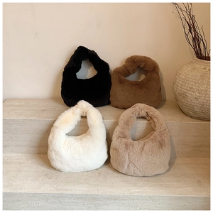 Plush dumpling bags in black brown cream and khaki on a stone display shelf