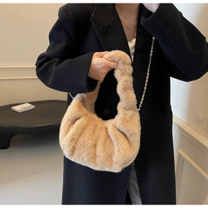 Detail of plush camel faux fur bag with pleated texture and golden chain strap