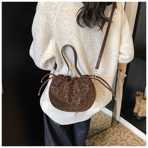 Braune Handtasche mit Leopardenmuster und Kordelzug getragen auf einem Strickpullover