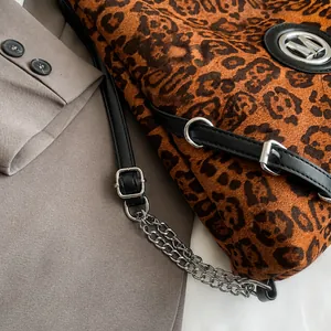 Detail der Tragetasche mit Leopardenmuster, dünnem Riemen und metallischem M-Logo