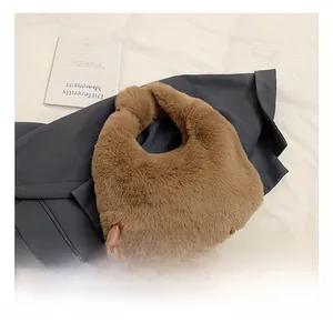 Detailed texture of brown faux fur dumpling bag styled with grey blazer and books