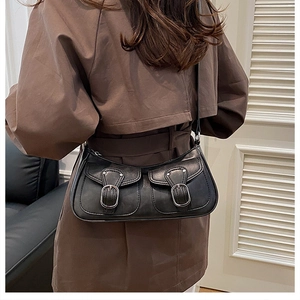 Detail of vintage black shoulder bag with dual flap pockets and silver metal buckles