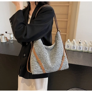 Detail der grauen Strick-Hobo-Tasche mit braunen Lederriemen am Modell für den Alltag