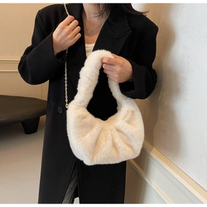 Detailed macro of plush faux fur texture on beige cloud hobo bag with gold chain