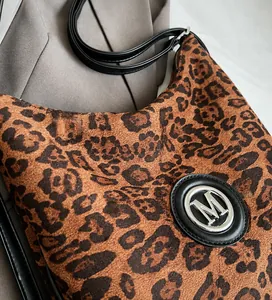 Detail der Tragetasche mit Leopardenmuster, weichem Wildleder und metallischem M-Logo