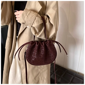 Detail der Leoparden-Beuteltasche mit Kordelzug und Silber-Hardware zu einem Trenchcoat